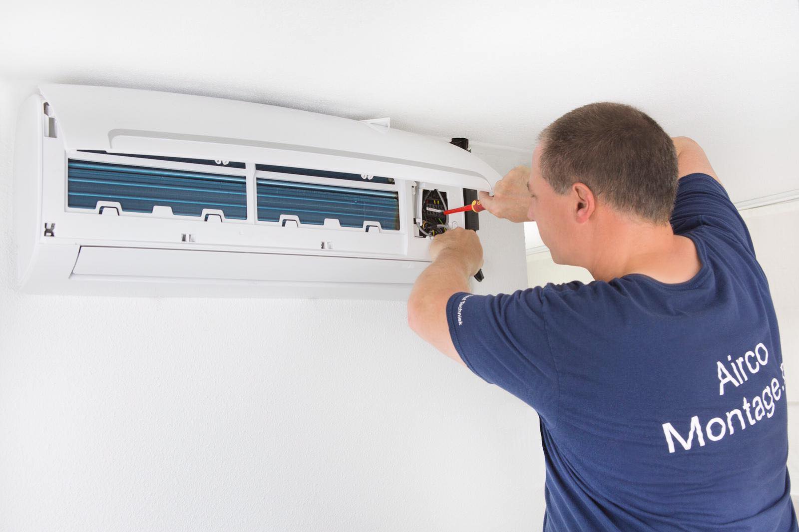 André Neutink van De Neut Techniek aan het werk aan een airco-binnenunit