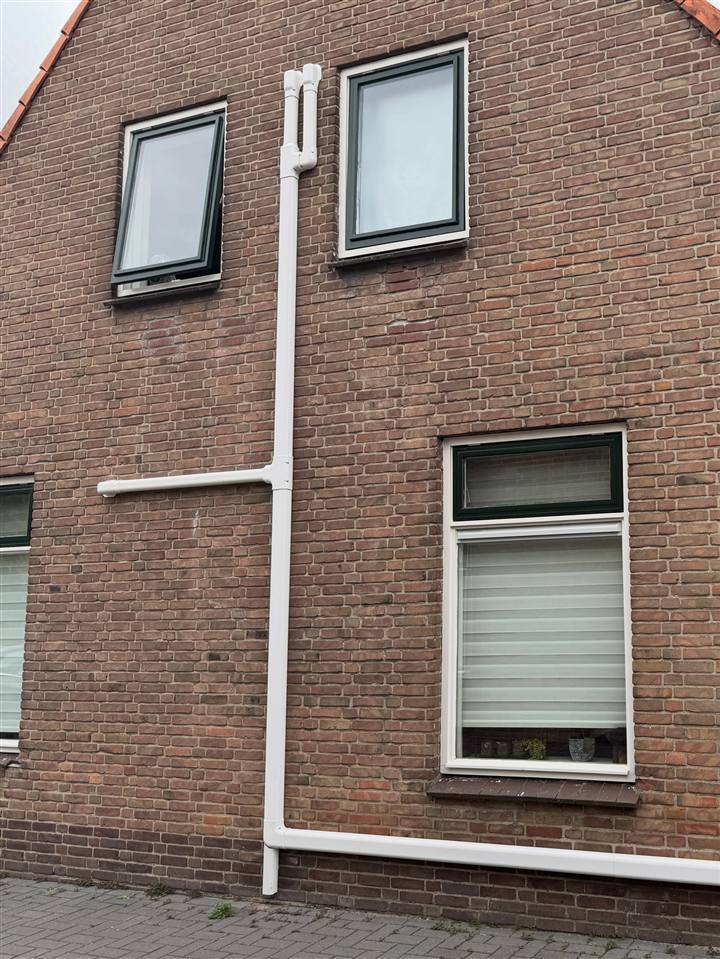 Dezelfde gevel in Oldemarkt na de uitbreiding, met een grotere witte leidinggoot