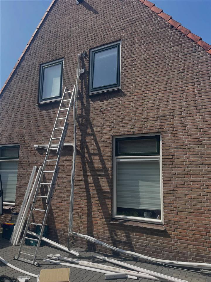 Gevel in Oldemarkt voor de uitbreiding van de airco, met ladder en oude leidinggoot